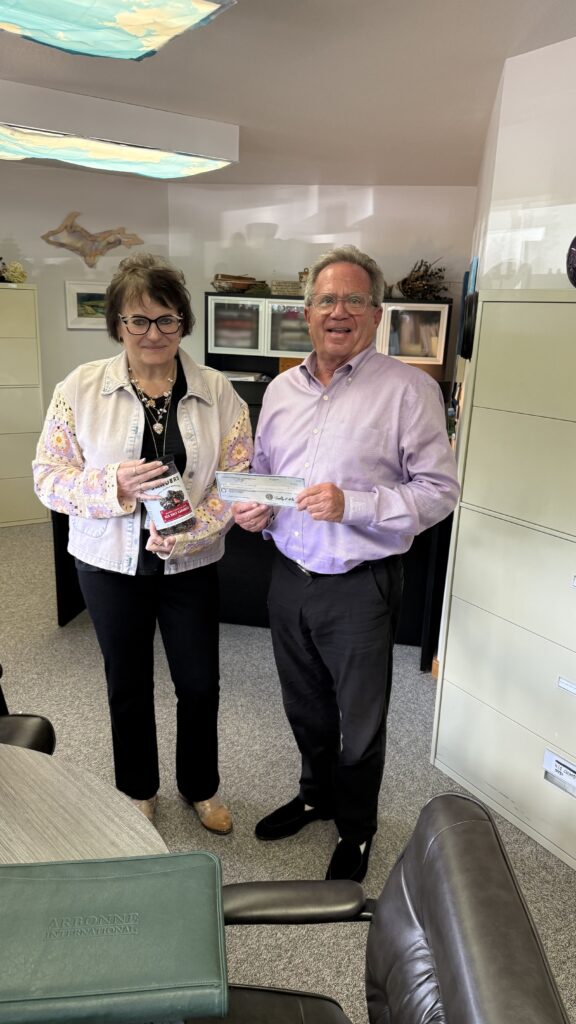 Hope Tarnaski from Gogebic Community Health receiving the 2025 dividend check